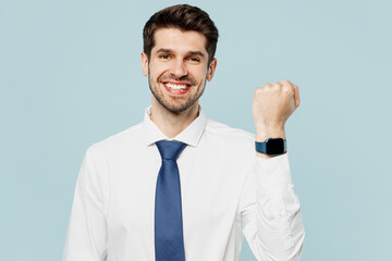 Young happy fun employee IT business man corporate lawyer in classic formal shirt tie show smart watch with blank screen work in office isolated on plain pastel light blue background studio portrait