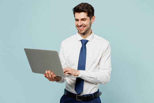 Young Smiling Employee IT Business Man Corporate Lawyer Wear Classic Formal Shirt Tie Work In Office Hold Use Work On Laptop Pc Computer Isolated On Plain Pastel Light Blue Background Studio Portrait.