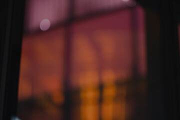 Fototapeta premium A defocused photo creates an abstract wallpaper out of orange and pink panels of glass combind with reflections and architectural details.