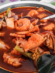 Tom yum kung Spicy Thai soup with shrimp and vegetable in a bowl. Top view, copy space.