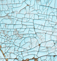 Cracked blue paint on the surface of the old wall as a background
