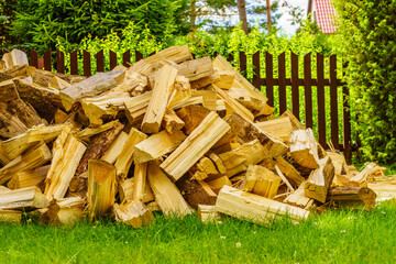 Stack of firewood on green grass.