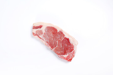 A piece of raw beef, sliced, tabletop on a white background