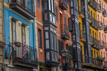 Details of street full of colorful houses in Bilbao, flowers on balconies