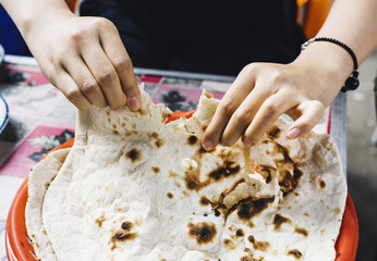 Woman enjoying a round traditional Pakistani naan