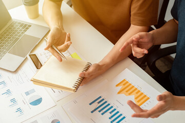 Business owners and partners analyze earnings charts to plan investments for the next quarter,...