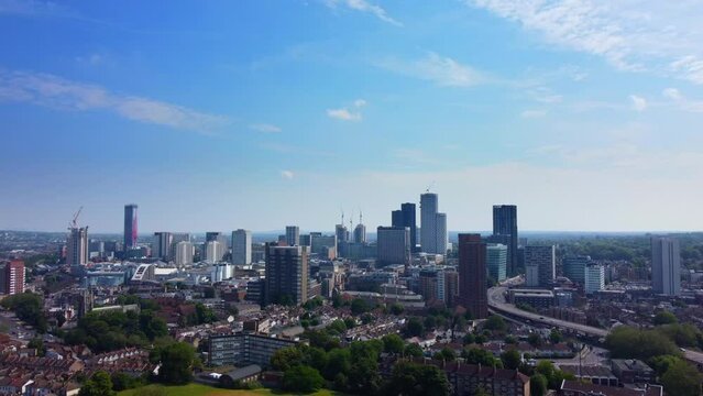 Cinematic drone shot of South London suburb with skyscrapers on skyline
