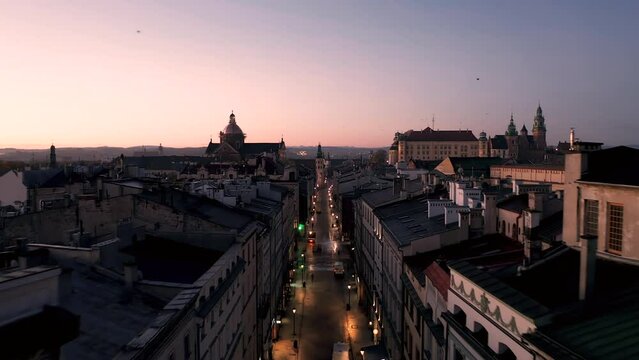 Aerial view of Old Town - tenement houses on Grodzka street and Wawel Castle in Krakow (Cracow), Poland during magic sunrise with soft morning light in pink, pastel colors.