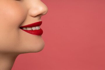 Smile of  girl with red lips on a pink background