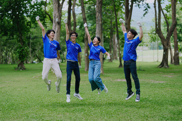 Volunteers of various nationalities are showing solidarity, donating their personal time, holding black trash bags to collect plastic waste for recycling to reduce pollution in a public park.