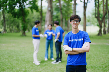 Obraz premium Multiethnic volunteers donate their time holding black garbage bags to collect plastic waste for recycling to reduce pollution in a public park.