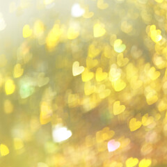 Blurred background in yellow tones .Abstract small hearts flare blur background. Heart shaped sun reflection.