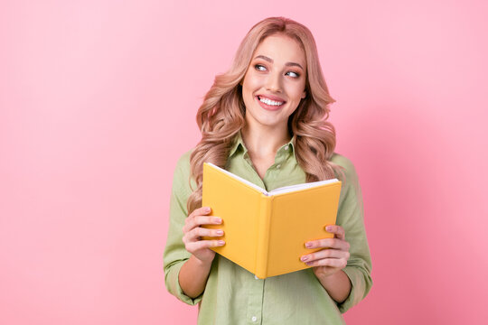 Photo of clever positive minded lady hold opened book look empty space isolated on pink color background