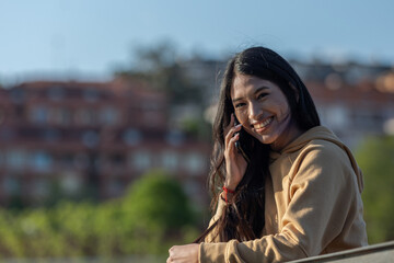 young girl walking in the park while talking and using her mobile phone