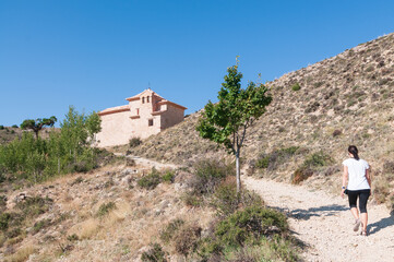 Una senderista camina subiendo hacia la ermita de la virgen del Carmen en Albarracín, Teruel,...