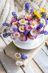 Fototapeta na wymiar Bouquet of daisy with pink flowers in a ceramic white mug, wooden background. Romantic still life, summer or spring inspiration, cozy home decor. Greeting card for birthday, anniversary, Mother's Day