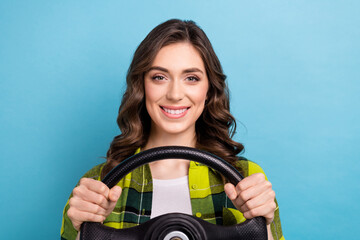 Photo of good mood pretty girl curly hairdo dressed checkered shirt holding steering wheel buy new car isolated on blue color background
