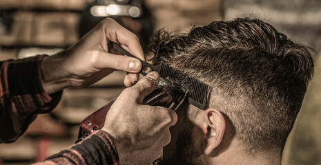 Bearded man in barbershop. Haircut concept. Man visiting hairstylist in barbershop. Barber works...