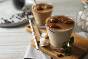 Delicious iced coffee on white wooden table, closeup. Space for text