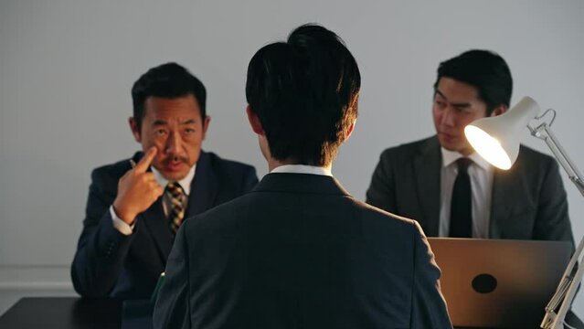 取り調べする刑事と容疑者