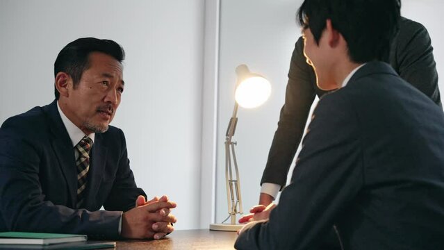 取り調べする刑事と容疑者
