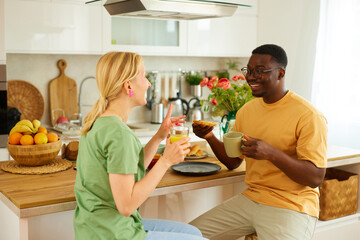 Multiracial couple enjoying breakfast together at home
