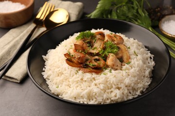 Delicious rice with parsley and mushrooms on grey table, closeup