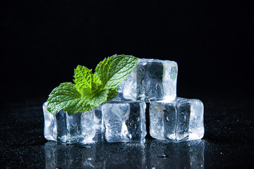 Ice cubes and fresh mint leaves isolated on black background	