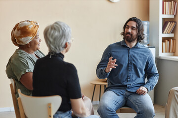 Portrait of male psychologist leading mental health support group for senior people
