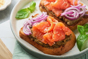 Sandwiches with salted salmon, avocado guacamole, red onions and basil. Smorrebrod. Set of danish open sandwiches. Healthy food, breakfast. Clean eating, dieting, vegan food concept. Top view.