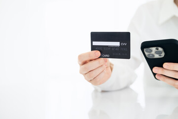 Online payment,woman's hands holding a credit card and using smart phone for online shopping