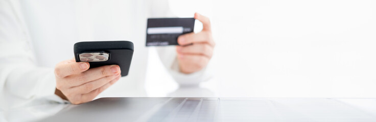 Close up view, young asian woman holding credit card and smart phone to shopping online and paying her order, People relax on holiday use technology from smart phone for the convenience of daily use