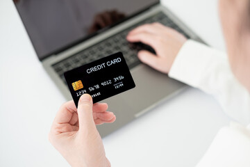 Hands holding credit card and using laptop. Online shopping