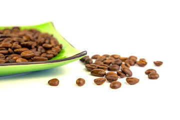 Coffee beans on a green square saucer, white background
