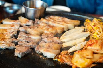 Obraz na płótnie Canvas Fresh and delicious iron pan-fried black pork meal in Jeju Korean restaurant.