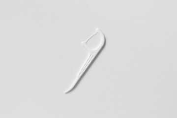 Plastic white dental toothpick with dental floss on white