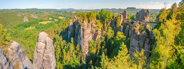 Panoramic view over Bastei sandstone rocks and ancient bridge at sunset colors in the national park...