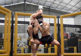 Two male athlete boxing competition in ring. Diverse ethnic men punch fighting in MMA kickboxing...