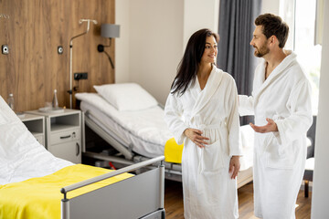 Obraz premium Mid adult couple during rehabilitation in medical ward. Patients resting in high quality medical suites after some procedures