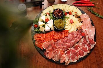 Cheese and cold cuts board, tapas, selective focus. Appetizers buffet with tasty meat snacks, pickles, top view.