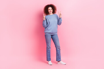 Full length photo of sweet cheerful lady wear blue sweatshirt showing two v-signs isolated pink color background