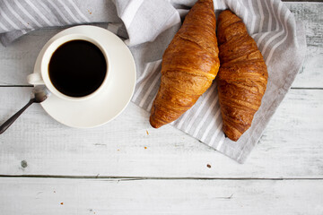 Breakfast with coffee, croissants and strawberries on the table. Morning