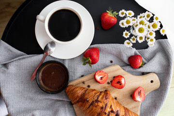 Breakfast with coffee, croissants and strawberries on the table. Morning