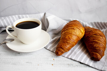 Breakfast with coffee, croissants and strawberries on the table. Morning