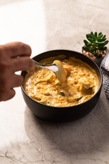 Coconut Curry Dish in a Black Bowl on a Marble Counter 