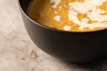Coconut Curry Dish in a Black Bowl on a Marble Counter 