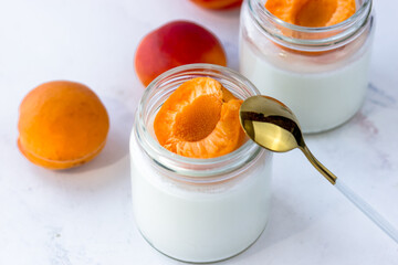 Homemade yogurt with juicy apricots. Yogurt on a white table