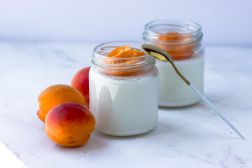 Homemade yogurt with juicy apricots. Yogurt on a white table. Side view