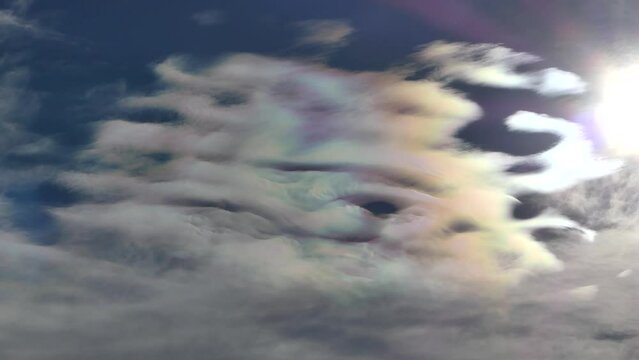 Natural blue sky with colorful decorative clouds moving very slowly - Cloud iridescence, irisation around sun. Observed in warm, sunny, windy autumn weather with mountain winds on October in Poland.
