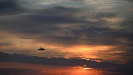 Fototapeta na wymiar landing airplane on the background of the sunset